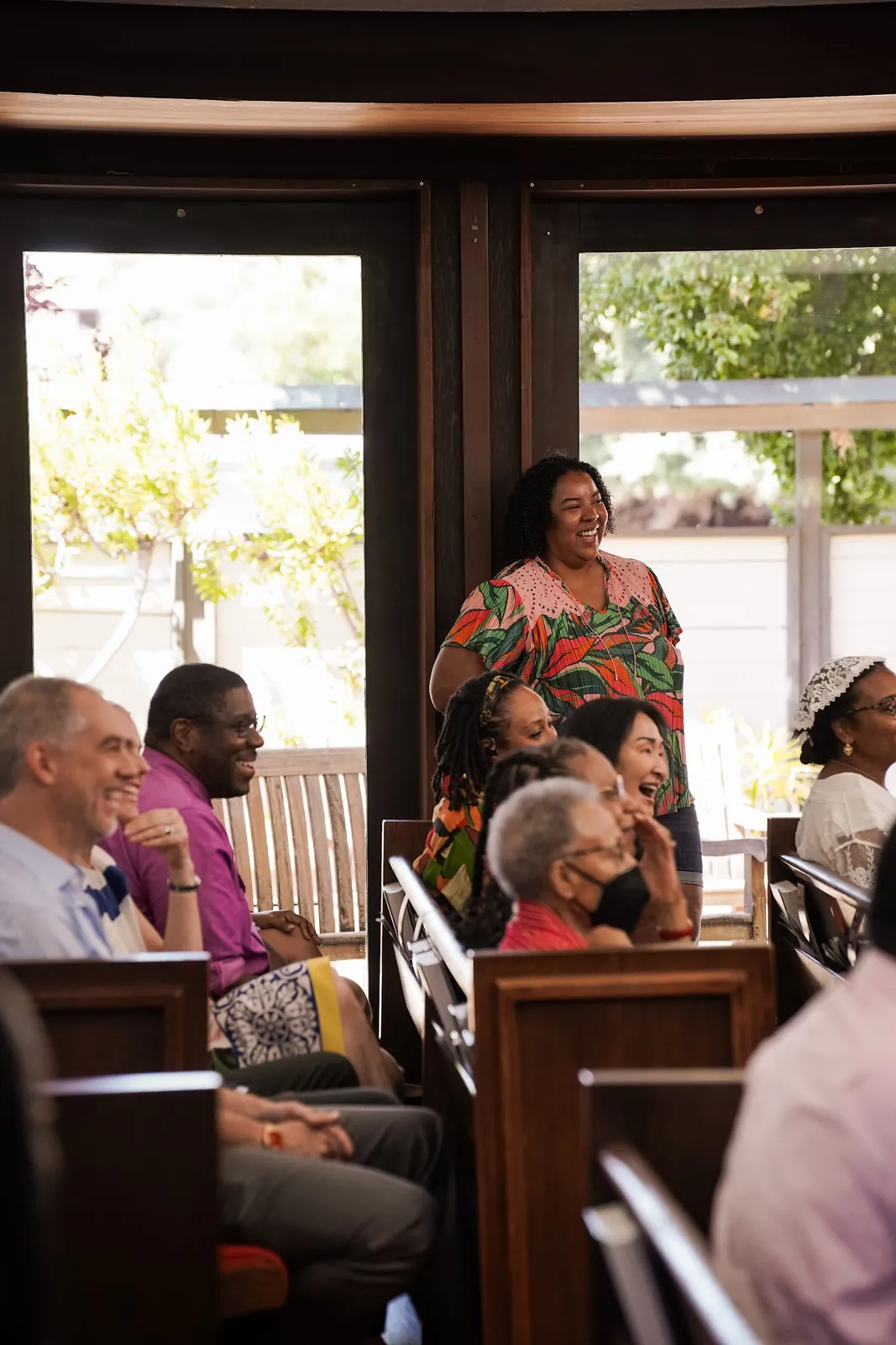 People smiling together in the sanctuary pews.